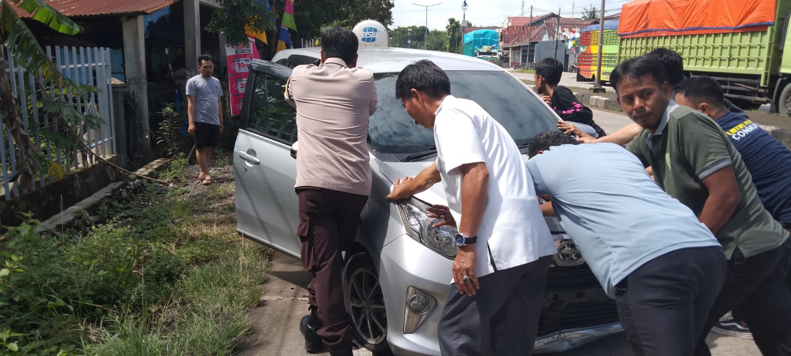 Anggota Polsek Tanete Rilau Komandoi Warga Bantu Mobil Yang Pecah Ban Di Jalan Poros Untuk Hindari Kecelakaan